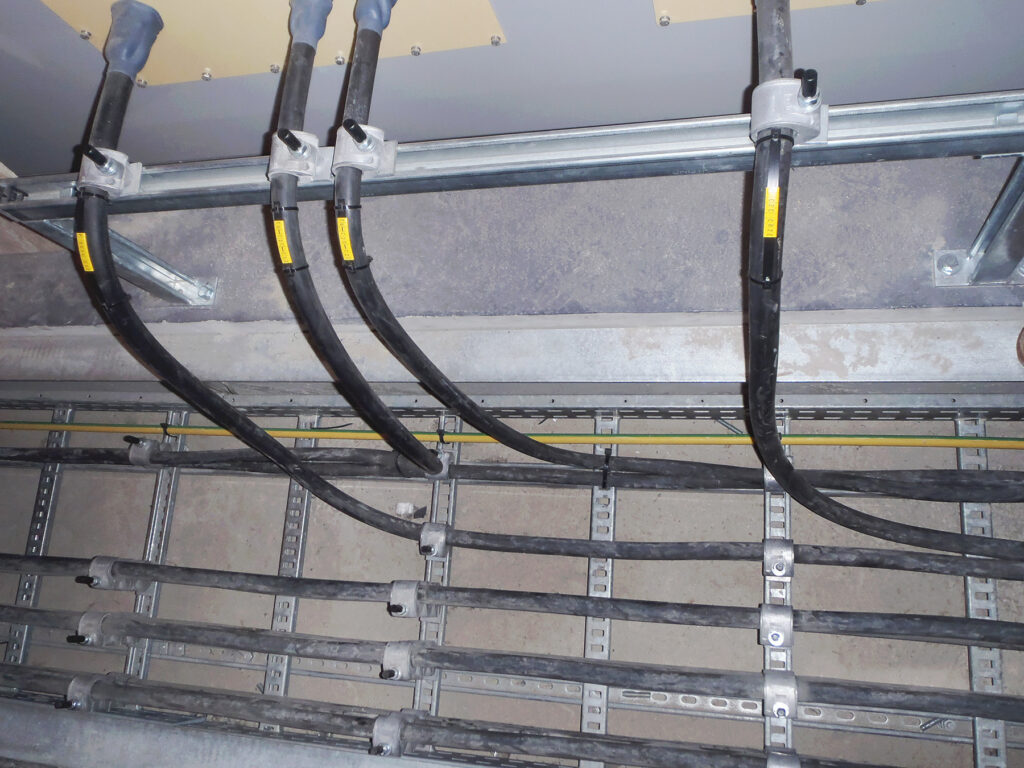 High and low voltage cables leaving trench to switchboard at regular intervals